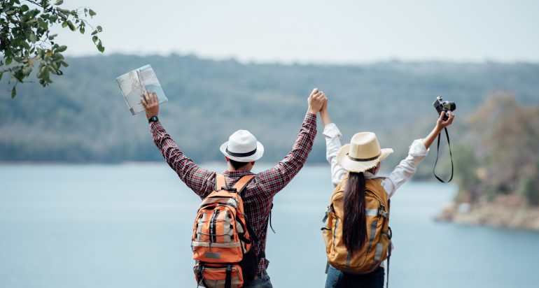 Couple family traveling together,Tourist couple Backpack along mountains and coast, freedom and active lifestyle concept